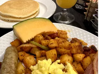 Photo of eggs, bacon, potatoes, pancakes and mimosas