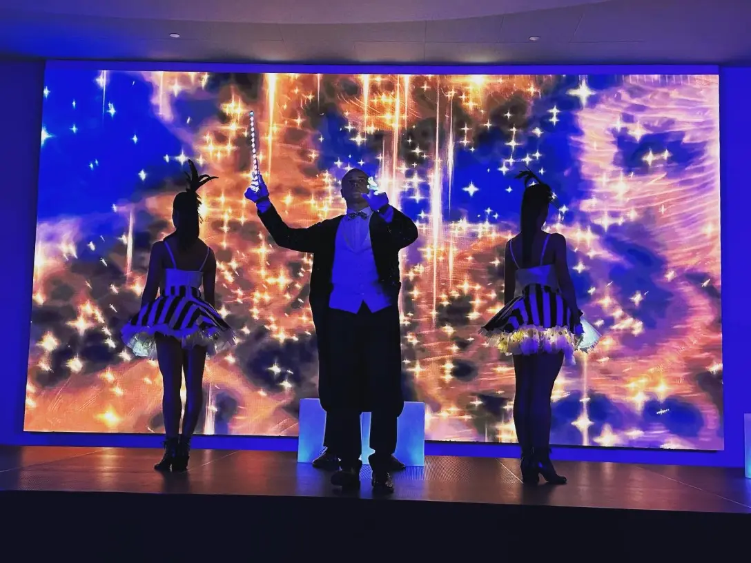 Photo of performers and a glittery background