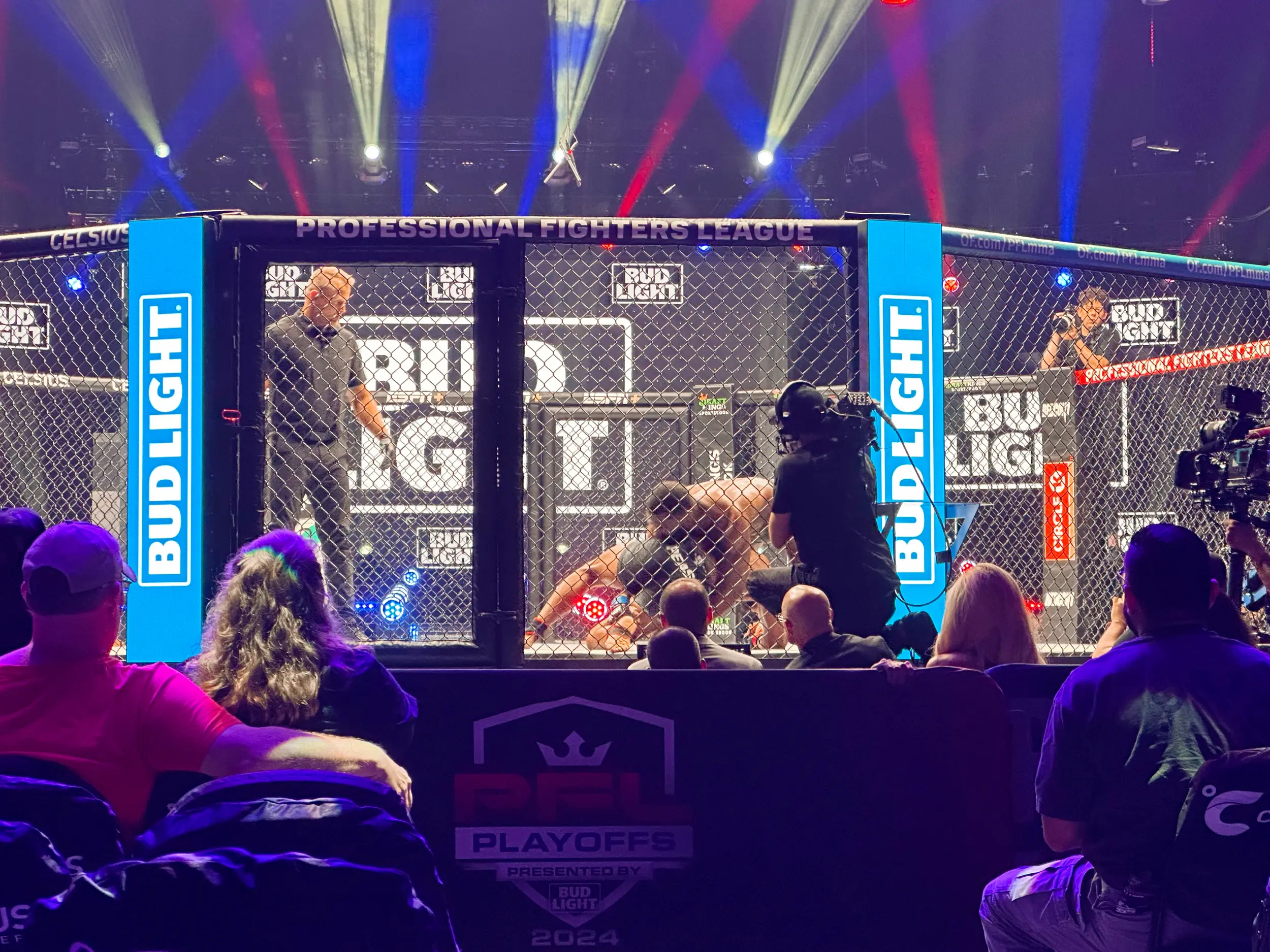 Photo of an MMA ring with contestants grappling